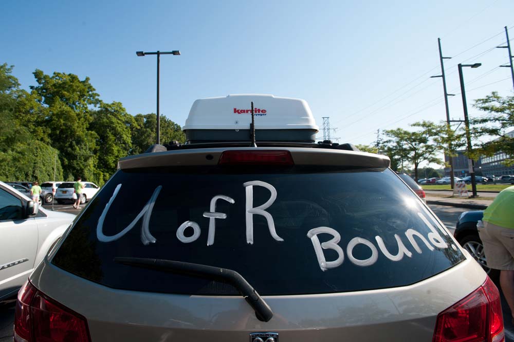 rear windshield of a packed car is painted with the words UofR Bound