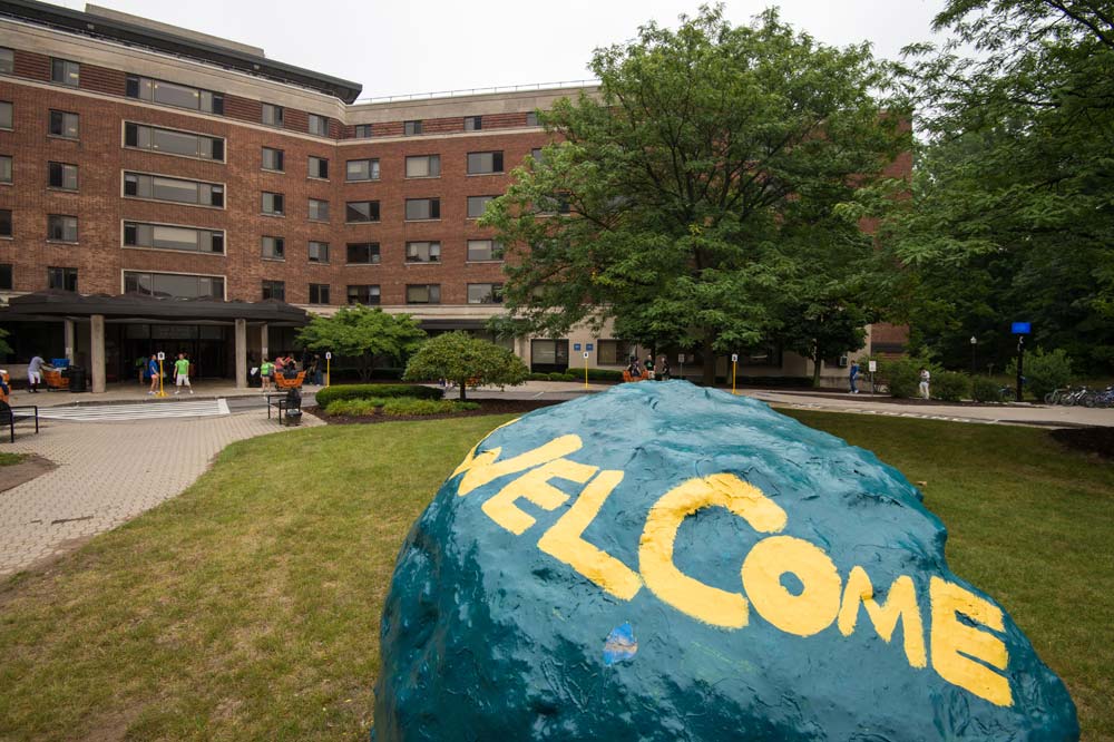 large rock in front of Susan B. Anthony Hall painted with the word WELCOME