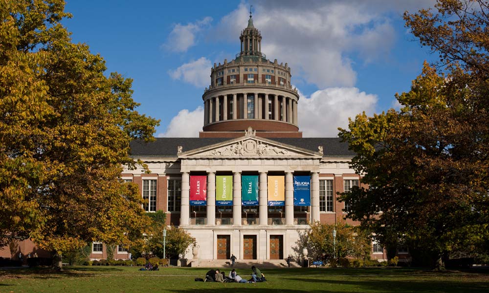 Rush Rhees Library adorned with colorful banners on a fall day.