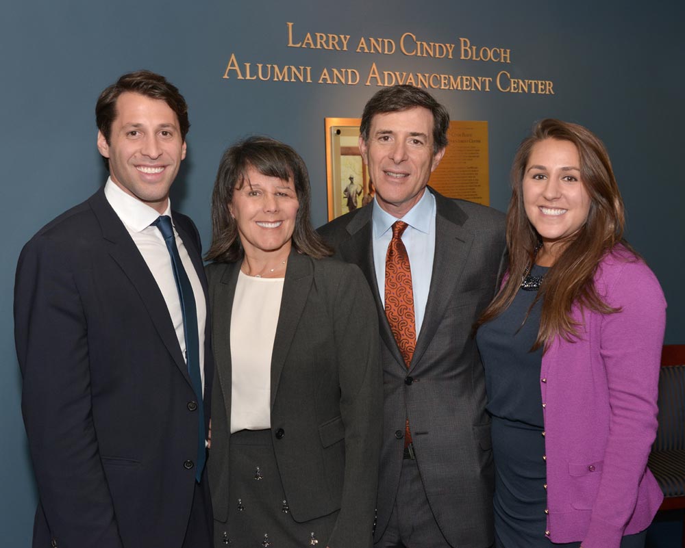 The Bloch family in front of the new sign for the Alumni and Adancement Center than now bears their name