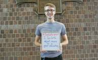 man holding a sign that reads I Turn Out For equal access to a great education. 