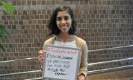 woman holding a sign that reads I Turn Out To Vote because we need change from both inside and outside the system.