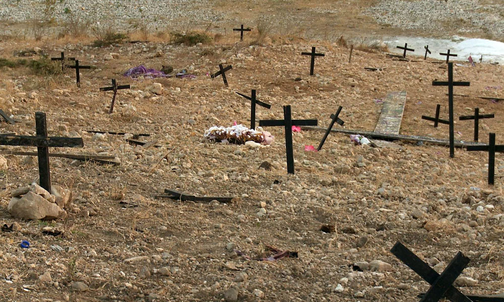 Feature image scene of devastation, with crosses marking graves