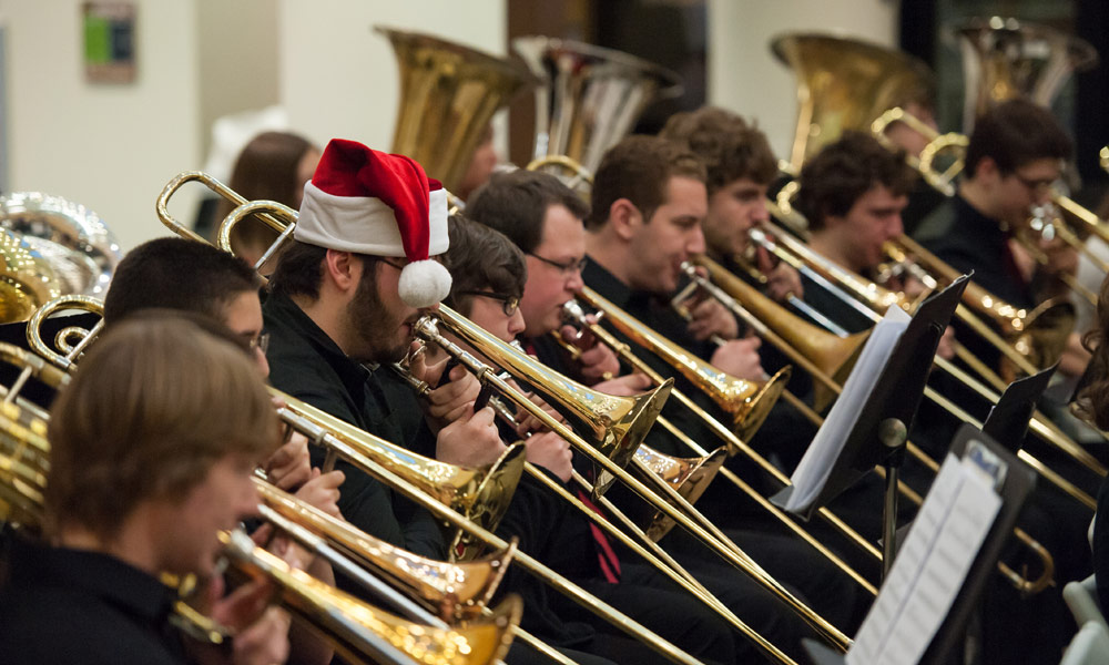 Feature image row of musicians playing trombones, one is wearing a Santa hat