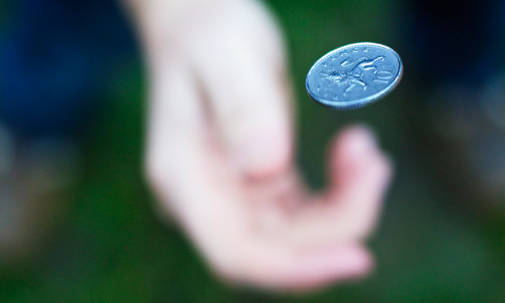 close-up of a hand flipping a coin