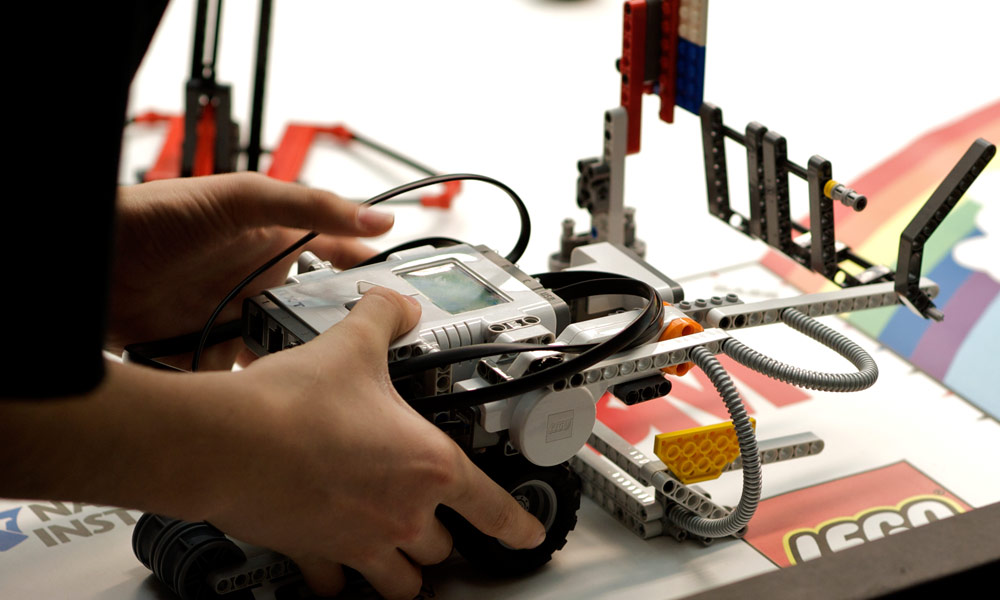 child's hands holding a LEGO robot