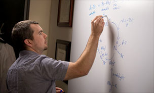 Feature image man writing equations on whiteboard