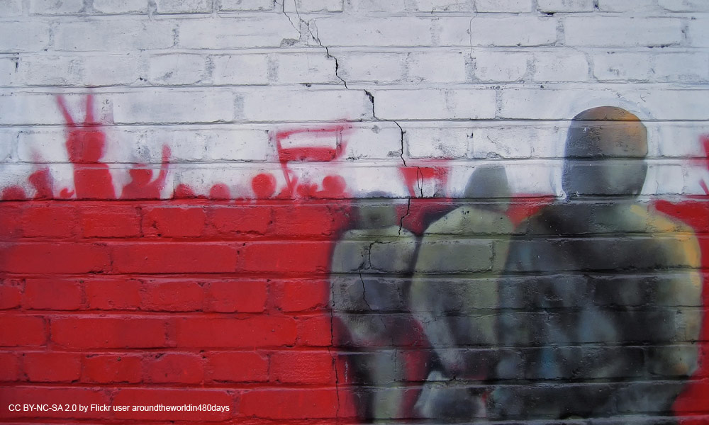 red and white graffiti on a brink wall mimics the Polish flag, protests