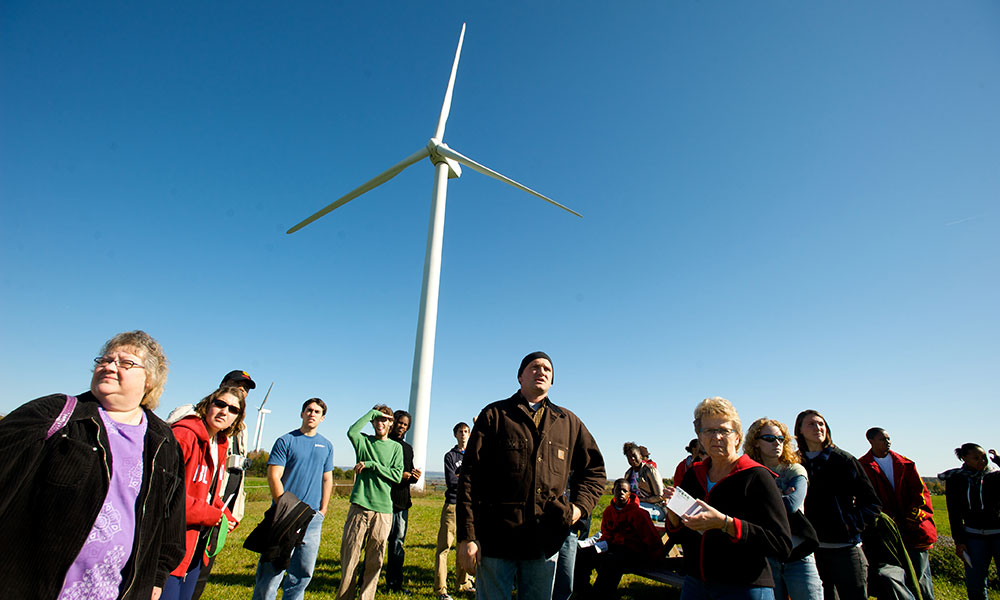 Feature image group of people standing in front of a wind turbine