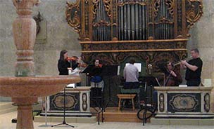 Feature image musicians practicing by a large baroque organ