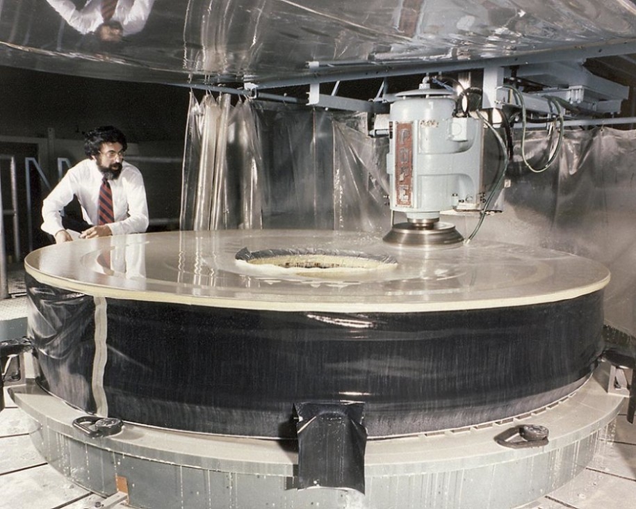 man polishing large telescopic mirror