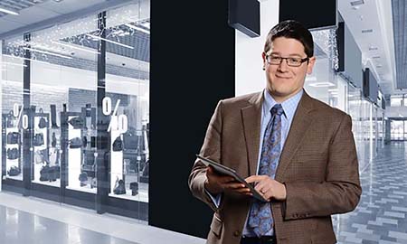 man standing in a store holding a tablet