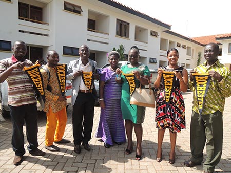 group of students pose holding University of Rochester pennants