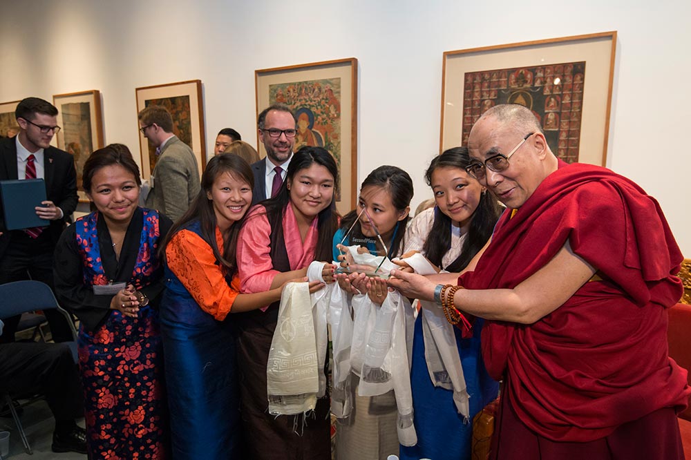 students pose with Dalai Lama after winning award