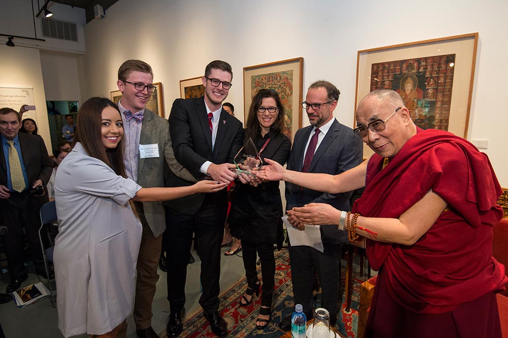 students posing with Dalai Lama after winning award