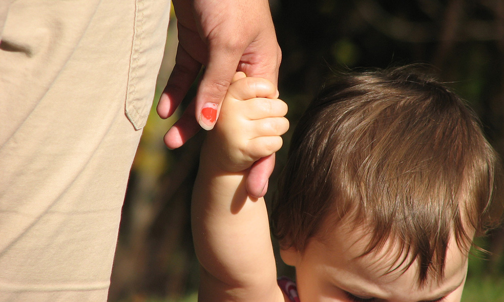 woman holding a child's hand