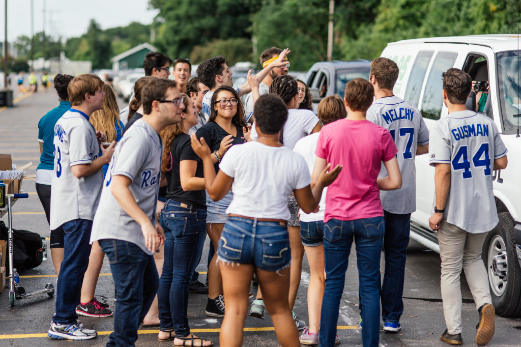 large group of students singing and dancing in parking lot