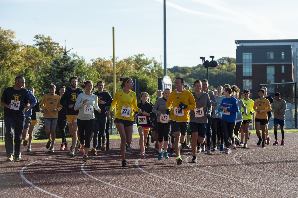 Participants run around the track at the start of the Alumni Fun Run in Fauver Stadium.