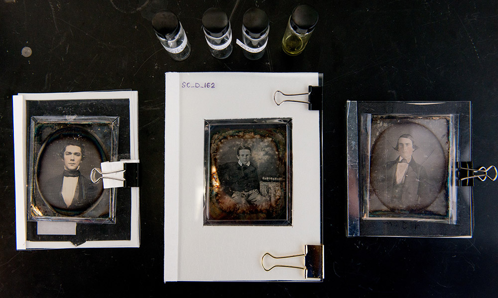 Feature image daguerreotypes on a table along with some chemicals in jars