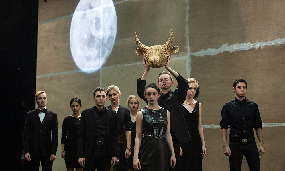 Feature image large group of actors on stage, one being crowned with a bull's head