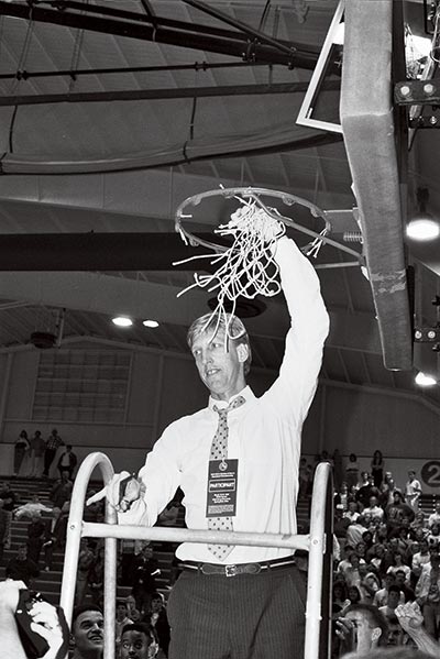 coach cuts down basketball net