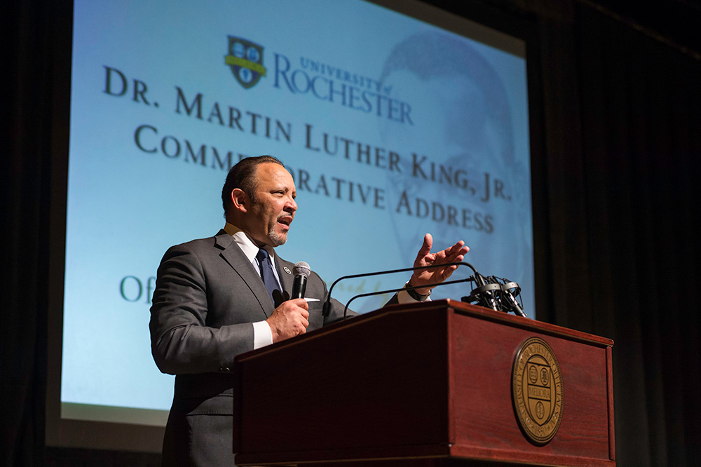 Feature image Marc Morial speaking before a photo of Martin Luther King