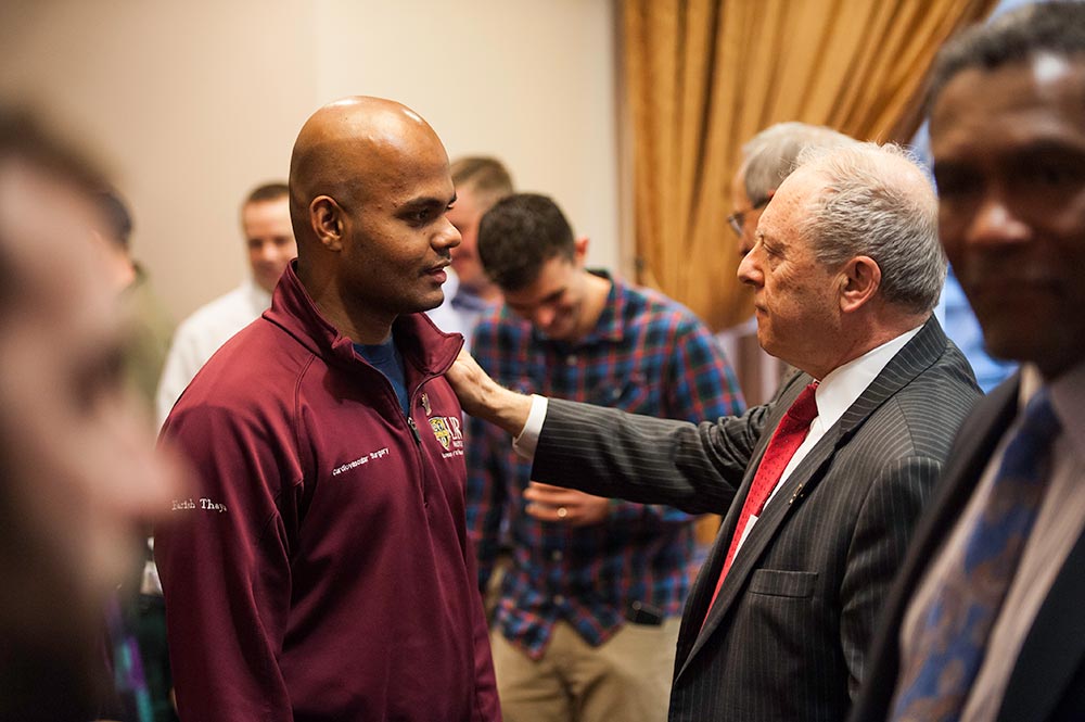 staff member receives a lapel pin