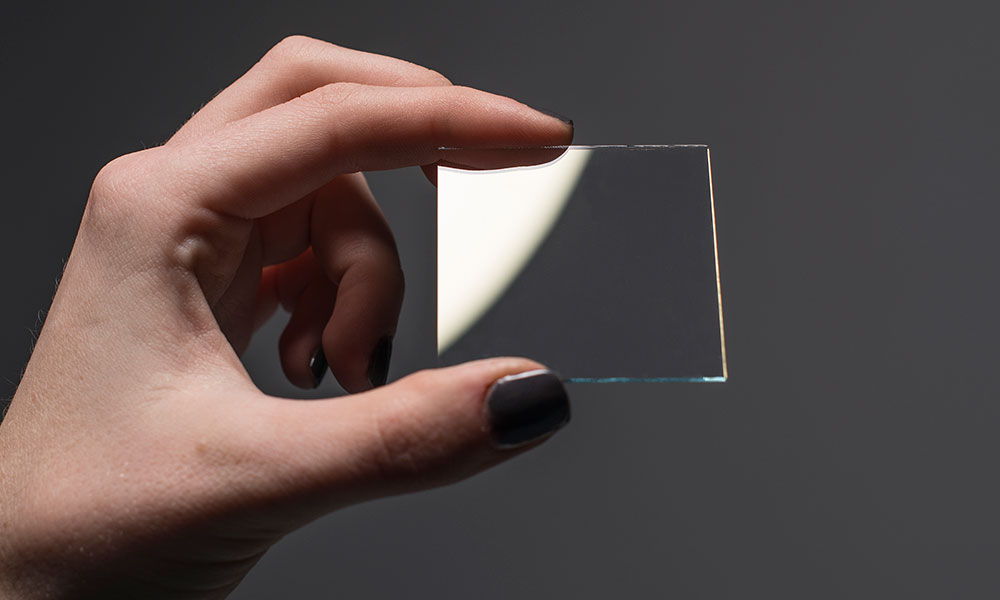 Feature image hand holding piece of clear indium tin oxide