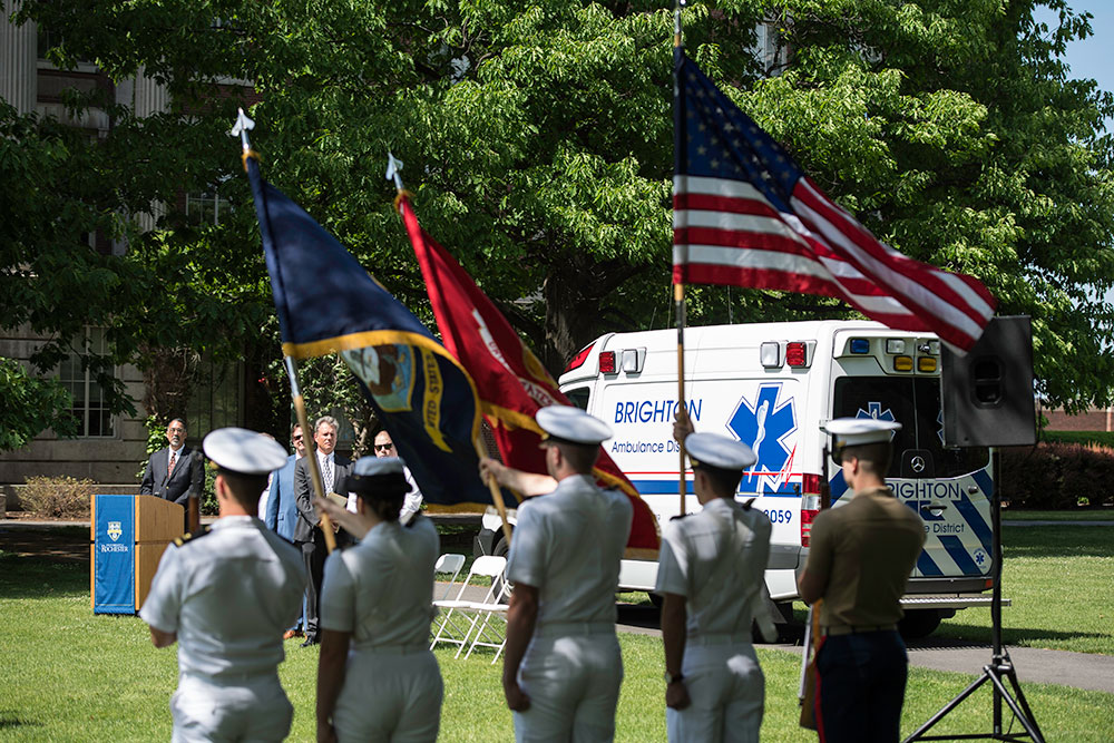 Feature image color guard stands in front of an ambulance parked on the Eastman quad