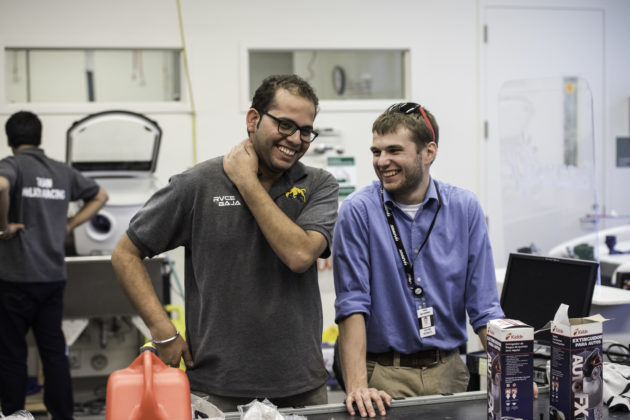 Yash Mehrotra from India's Team Helios, left, shares a laugh with Kevin Bonko '17, president of Rochester's Baja team, at the fabrication lab in Rettner Hall.