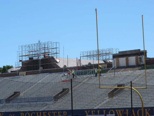 construction workers on top of Fauver Stadium bleachers.