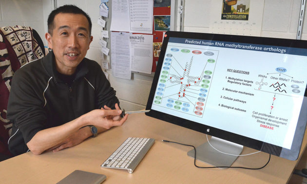 Dragony Fu in front of a computer in his office.