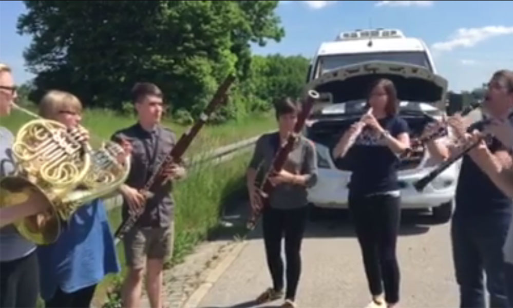Feature image screenshot from video of musicians playing by the side of the road