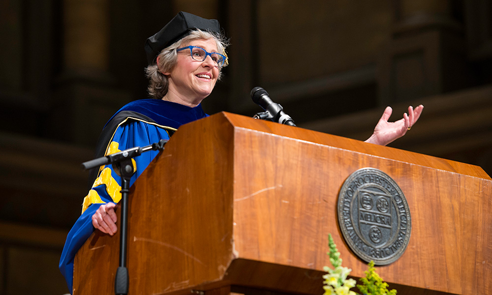 Feature image Mary Jo Heath behind podium delivering commencement address