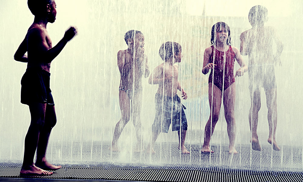 Feature image kids playing in a sprinkler