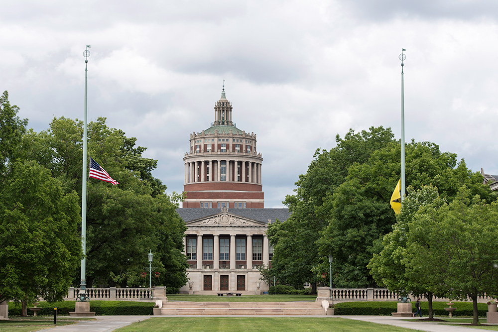 Feature image flags at half staff in front of Rush Rhees Library