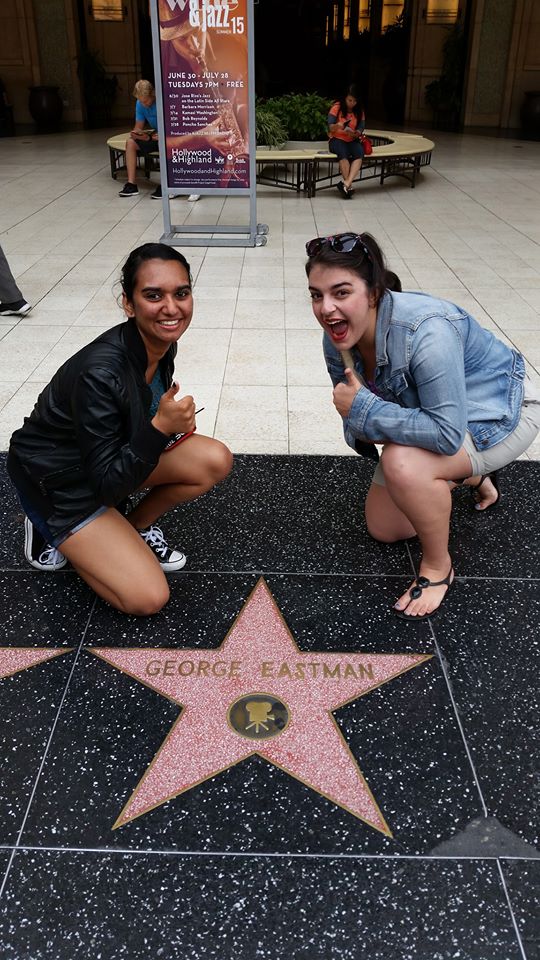 two students pose with star on sidewalk that says GEORGE EASTMAN