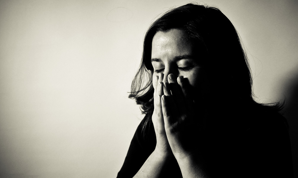 Feature image stressed woman holding her hands to her face