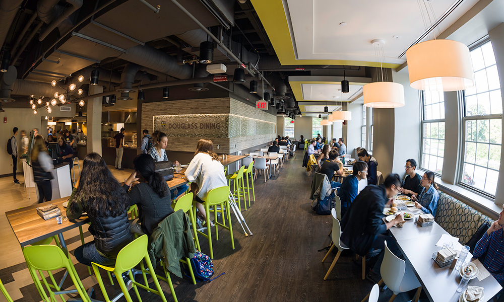 students in dining hall; sign reads DOUGLASS DINING.