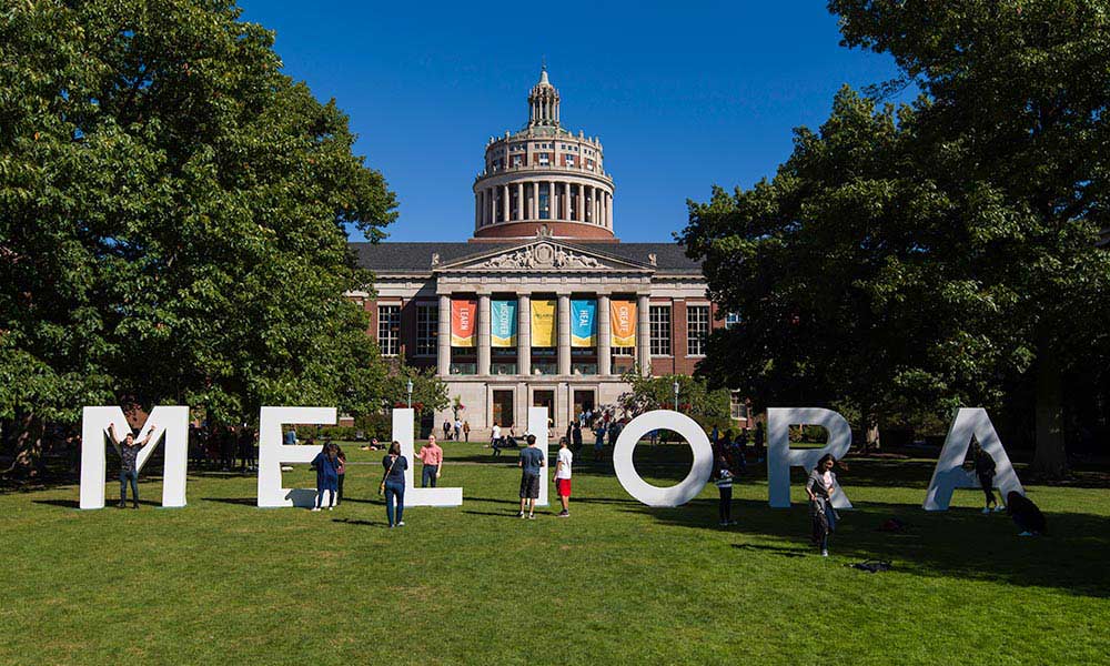 Feature image MELIORA in large letters in front of Rush Rhees Library