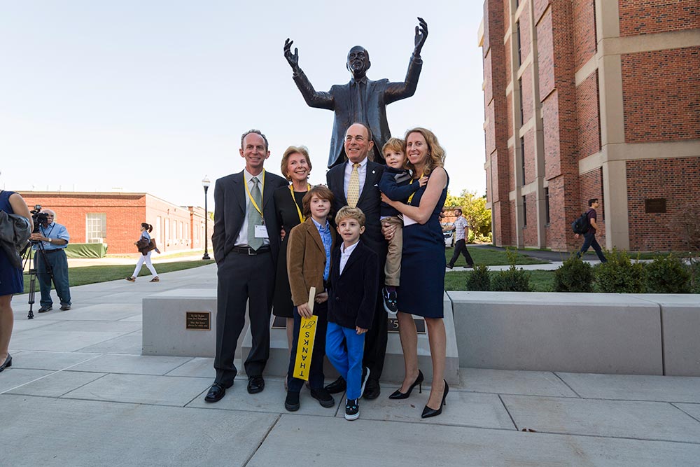 family poses in front of statue