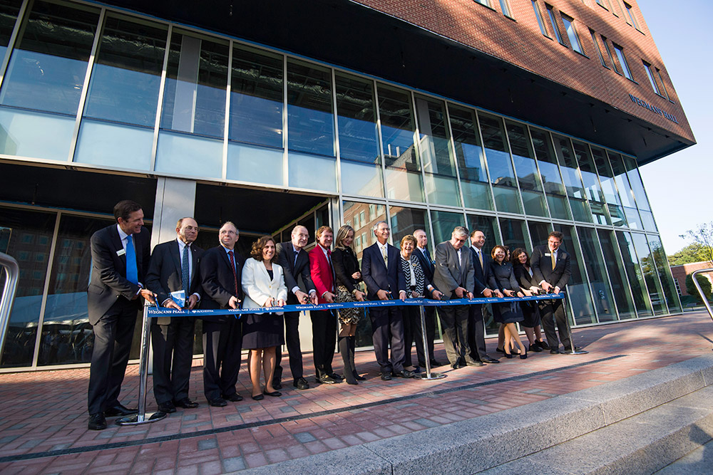 large group of people cutting a ribbon