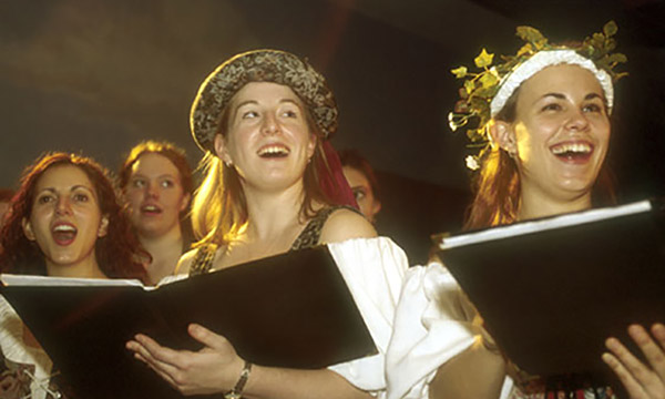 singing students dressed in medieval costumes