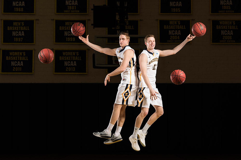 two basketball players leap into the air