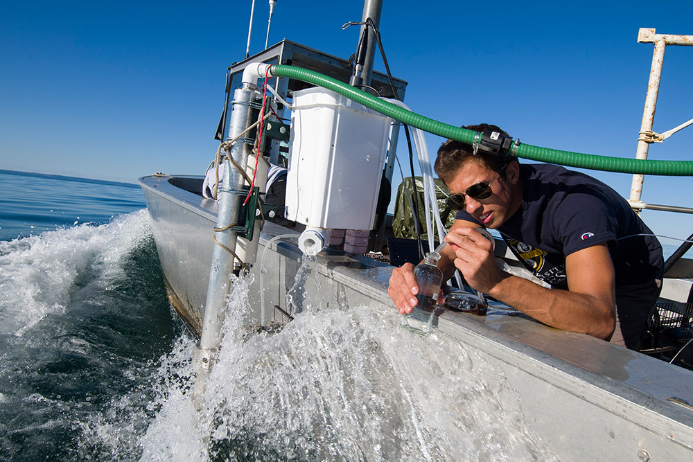 student with scientific instrument in a boat