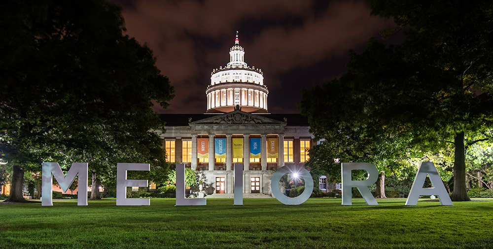 giant letters spell MELIORA in front of Rush Rhees Library