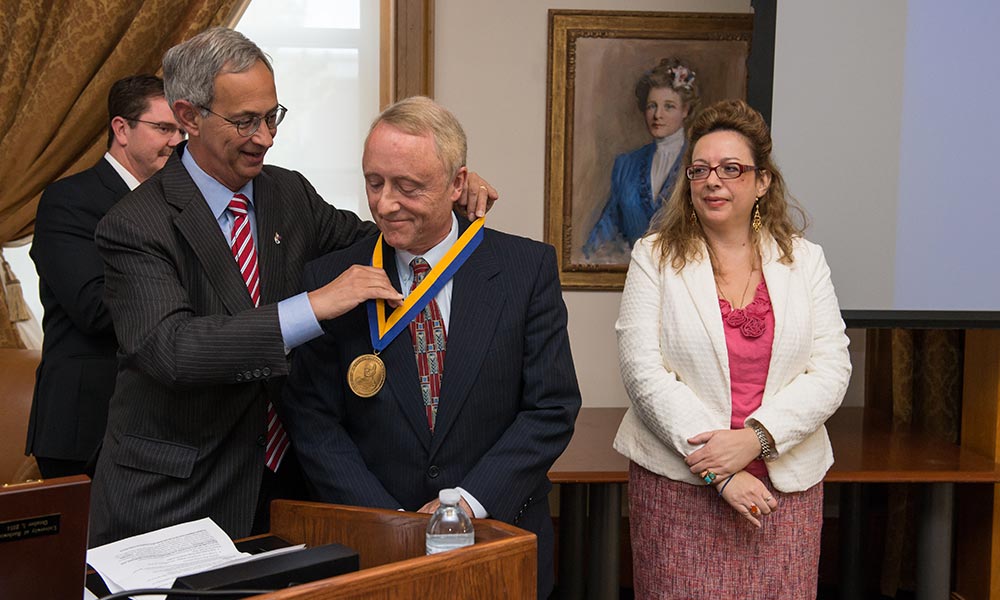 Kevin Parker receives medal from Joel Seligman