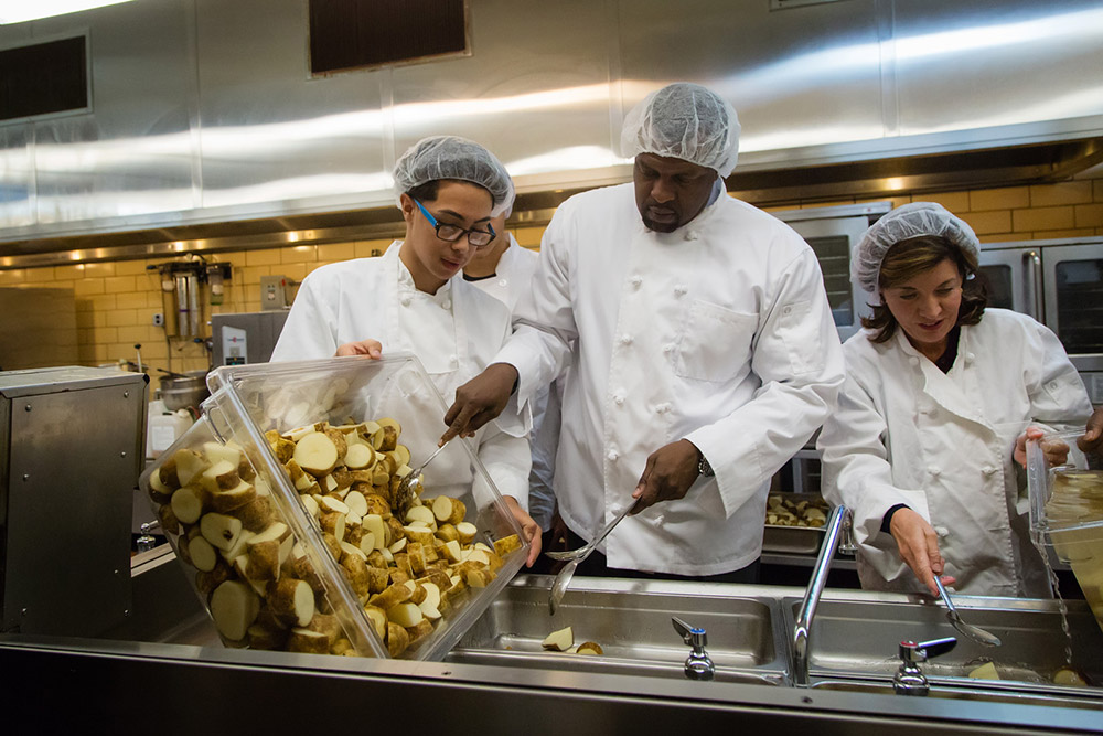 three people preparing meals