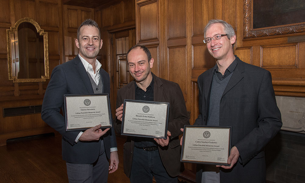Feature image three people pose for a portrait, holding awards