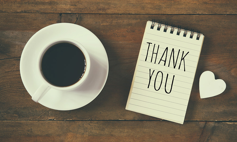 Feature image coffee cup with a notepad that says THANK You with a heart